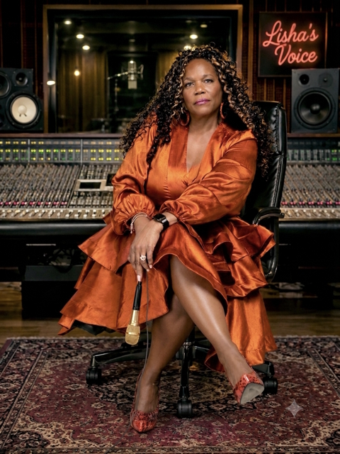 Lisha Lewis singing into a gold microphone